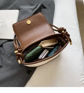 Vue détaillée de l'intérieur du sac en paille avec garniture en cuir et poche zippée