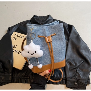 Blue denim bucket bag with brown leather accents and a cute white cloud plush pendant