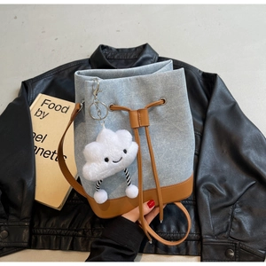 Detail of denim bucket bag with leather drawstring and cute white cloud charm