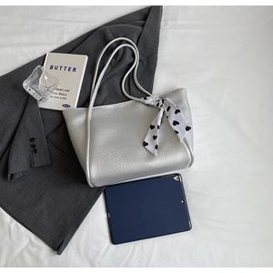 Detailed macro view of silver lychee texture tote bag with elegant heart print silk scarf