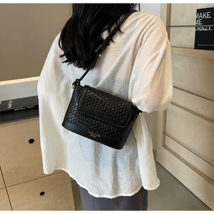 Détail du sac bandoulière tressé noir avec logo Fashion & Bag embossé sur le panneau en cuir
