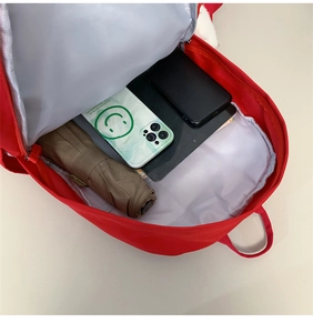 Dettaglio dell'interno dello zaino rosso capiente con scomparti per tablet e ombrello
