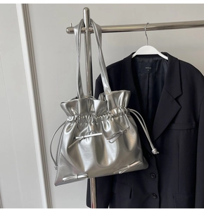 Close-up of silver metallic tote bag with drawstring closure and bow details