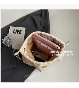 Top view of cream bucket bag showing large interior space with tablet and essentials