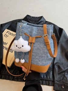Blue denim bucket bag with brown leather trim and a cute white plush cloud charm