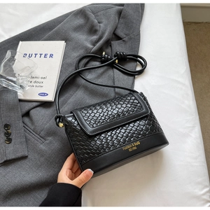 Détail du sac bandoulière noir à texture tissée avec logo et bandoulière nouée
