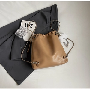 Detail of camel bucket bag with gold chain strap and cute white cloud charm