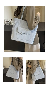 Gros plan sur un sac cabas bleu clair plissé avec nœud décoratif et bandoulière large