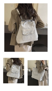 Détail du sac à dos argenté plissé à nœud, présenté à la main et porté à l'épaule