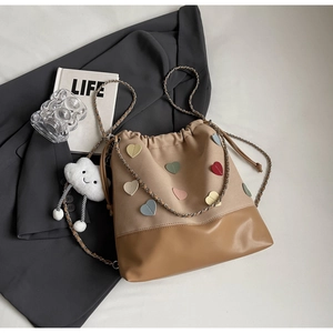 Close-up of bucket bag with colorful heart patterns, chain strap and cloud charm