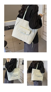 Détail du sac cabas crème à texture marbrée avec nœud élégant et fermeture éclair argentée