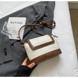 Détails de texture tissée blanche et coutures en cuir marron sur un sac bandoulière