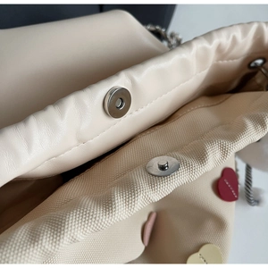 Detail of cream leather bucket bag showing silver magnetic closure and canvas lining