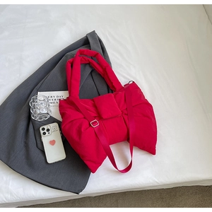 Vue de dessus d'un sac à bandoulière en nylon rouge en forme de nœud matelassé