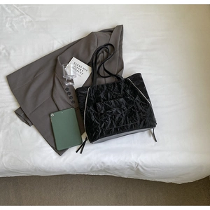 Détail du sac cabas noir avec texture velours, poche à nœud et fermetures éclair latérales
