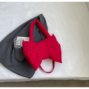 Détail macro du sac nœud en nylon rouge sur un costume gris avec des accessoires