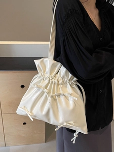 White glossy ballet-style tote bag with bow details and drawstring closure