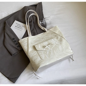 Détail du sac cabas plissé blanc crème avec nœud décoratif et fermeture éclair latérale