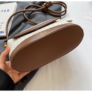 Gros plan détaillé du sac tressé avec inscription dorée Fashion & Bag EST.1985