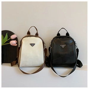 Detail of mini textured faux leather backpacks with metal plaque and patchwork design