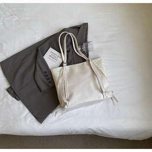 Détail d'un sac cabas crème avec double système de bretelles pour épaule et sac à dos