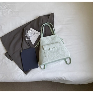 Détail du sac à dos cabas vert menthe avec un nœud élégant et une texture plissée