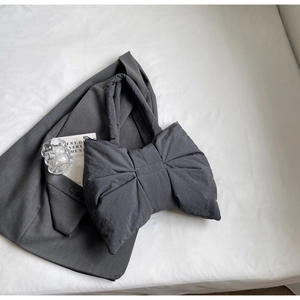 Détail du sac à bandoulière en nylon matelassé gris foncé en forme de nœud chic