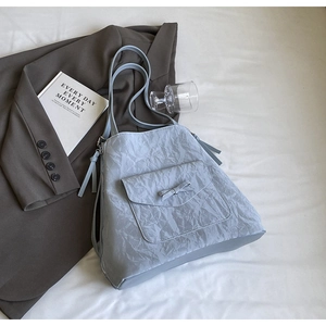 Détail du sac fourre-tout plissé bleu clair avec poche à nœud sur fond doux