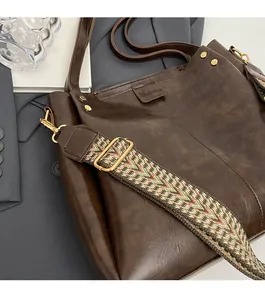 Dettaglio della borsa tote vintage marrone con tracolla intrecciata e borchie dorate
