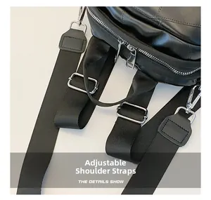 Detail of adjustable black woven shoulder strap with silver metal buckle on leather backpack