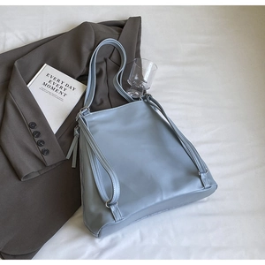 Détail du sac à dos en similicuir bleu clair avec bretelles réglables et fermeture éclair