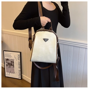 Detail view of cream backpack with geometric stitching and metal triangle logo plaque