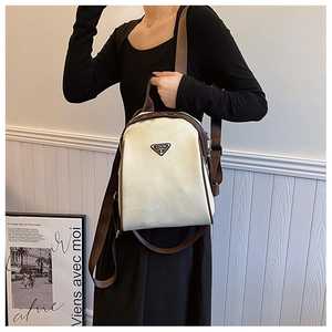 Detail view of cream leather backpack with geometric stitching and brown trim accents
