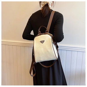 Detail showing high-quality creamy white faux leather texture and metallic triangle logo