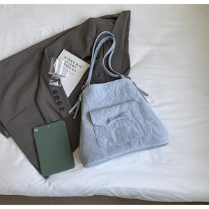 Détail du sac fourre-tout plissé bleu clair avec poche à nœud et doubles bretelles