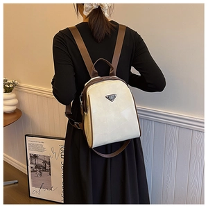 Close-up of cream PU leather backpack with triangle logo and brown zipper trim detail