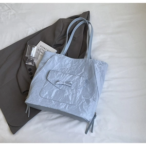 Détail du sac cabas bleu clair avec poche à nœud et fermetures éclair latérales