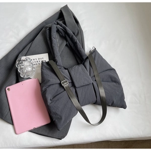 Vue de dessus d'un sac cabas gris matelassé en forme de nœud avec bandoulière