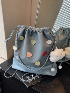 Blue canvas bucket backpack with colorful heart patches and plush cloud charm