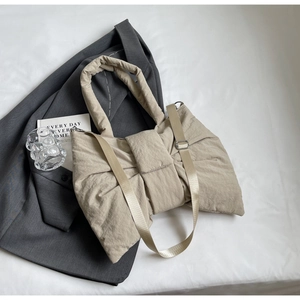 Gros plan détaillé d'un sac à main beige en nylon en forme de nœud avec texture plissée