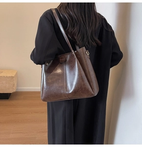 Dettaglio borsa tote in pelle marrone vintage con trama fine e cucitura verticale