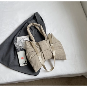 Détail du sac à bandoulière matelassé beige en forme de nœud avec sangle réglable
