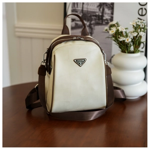 Detail of the JIPIN metal logo and geometric stitching on the leather backpack