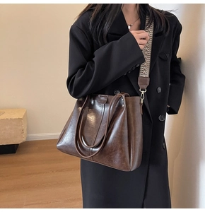 Dettaglio borsa tote marrone vintage con tracolla larga etnica e trama della pelle