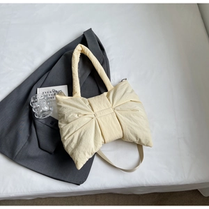 Détail du sac cabas matelassé jaune clair en forme de nœud avec texture nylon doux