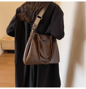 Dettaglio borsa tote marrone vintage con ampia tracolla etnica e fibbie dorate