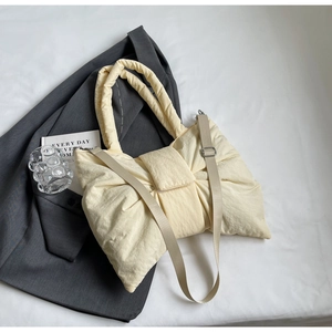 Détail du sac à nœud crème en nylon matelassé avec bandoulière réglable beige