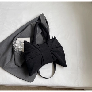 Détail du sac cabas nœud noir avec texture plissée douce et bandoulière fine