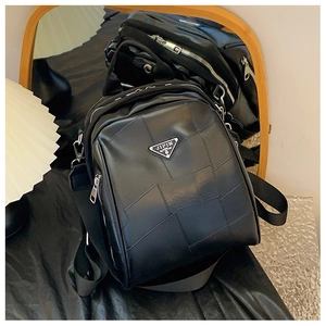 Detailed view of a black quilted backpack featuring a metallic triangular logo emblem
