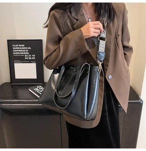 Dettaglio della borsa tote nera vintage con tracolla larga a motivo geometrico chic